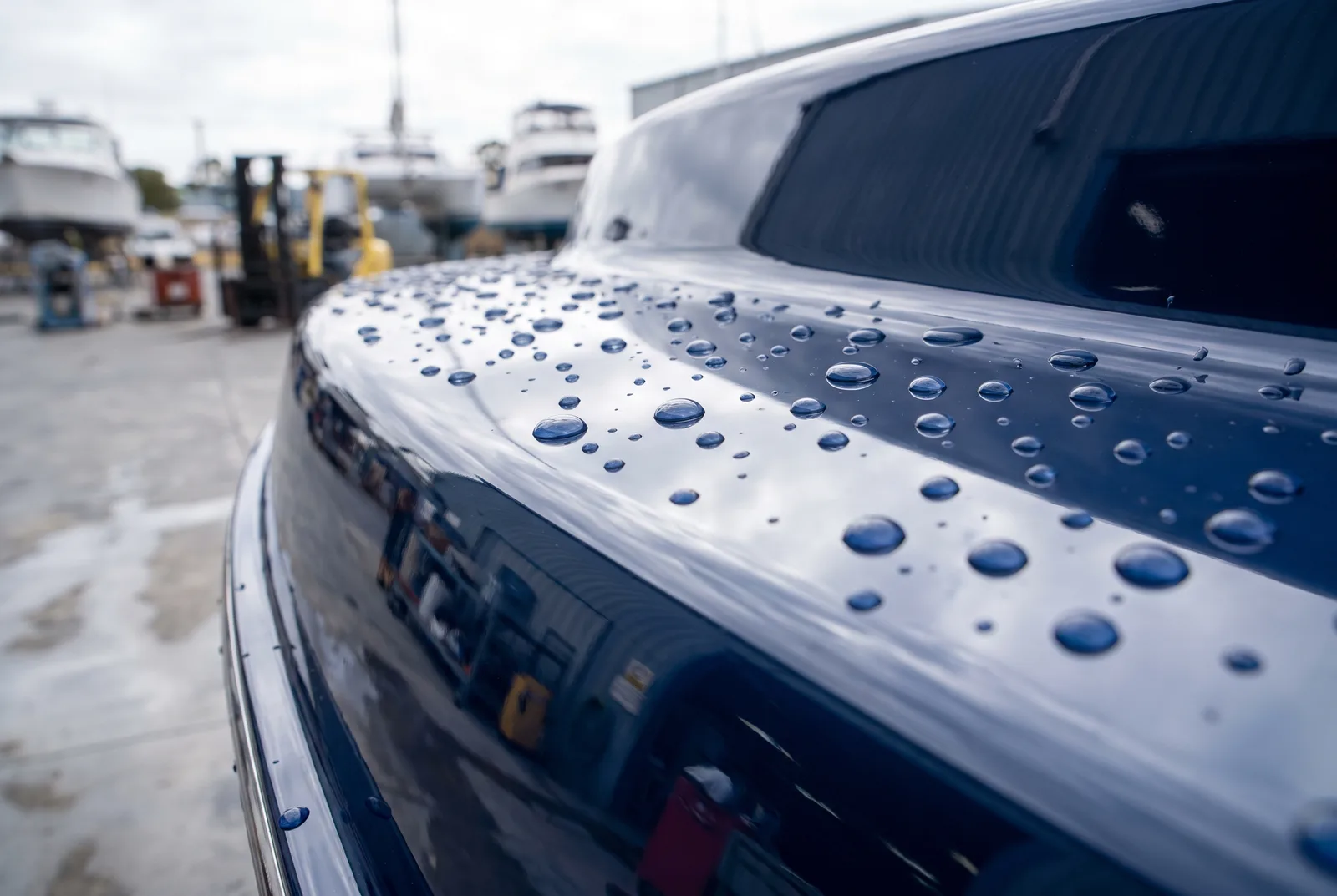Ceramic coated navy boat hull with beading water droplets after detailing in O'Connor WA