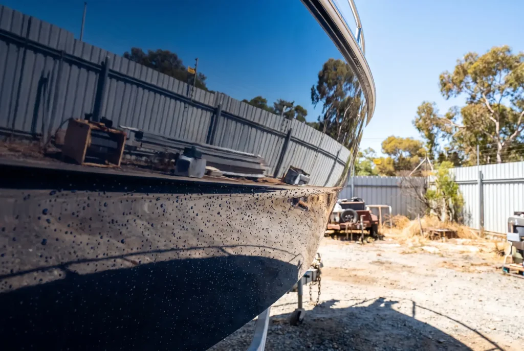 Polished navy boat hull after exterior detailing in O'Connor showing flawless mirror-shine gelcoat finish