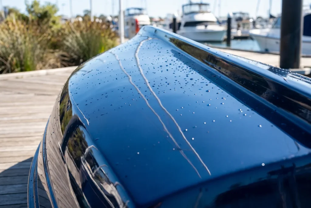 Paint correction result on glossy navy boat hull, Shipshape Boat Detailing O'Connor